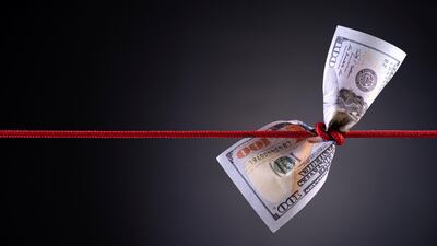American dollar tied up in red rope knot on dark background with copy space. business finances, savings and bankruptcy concept.
