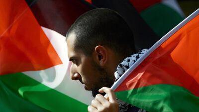 A demonstrator holds a Palestinian flag during a protest in support of the Palestinian cause. AFP
