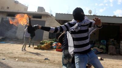 A demonstrator throws a Molotov cocktail towards Israeli security forces during clashes in the Palestinian town of Qabatiya, near Jenin in the north of the Israeli-occupied West Bank, on February 5, 2016. Jaafar Ashtiyeh / AFP