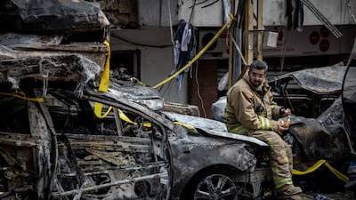 A firefighter takes a break on a vehicle destroyed in an Israeli airstrike in Beirut, Lebanon. Getty Images