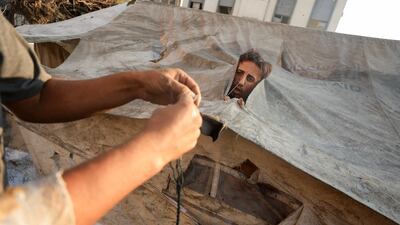 Palestinians repair their tent after it was damaged in an overnight Israeli air strike in Gaza city. Reuters