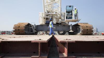 An oversized crane gets prepared for a slow journey over a short distance on metal plates specially made for the movement of the crane. Silvia Razgova / The National