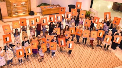 Participants in the Design and Dine event in Abu Dhabi show off their finished artworks. Image courtesy of Gemma Gallagher