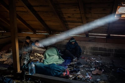 Afghan migrants wake up inside a cabin they use to sleep during their journey through the mountains of Bosnia to cross the border. JM Lopez / The National