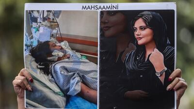 An Iranian protester holds a placard showing Mahsa Amini, during a protest following her death, outside of the Iranian Consulate in Istanbul, Turkey, on October 7. EPA / Sedat Suna