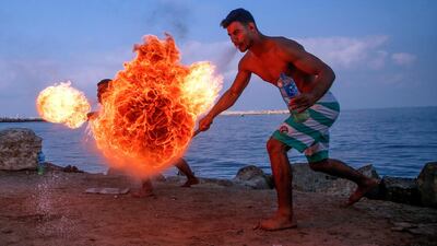 Palestinian firebreathers entertain children on a beach in Gaza City. AFP