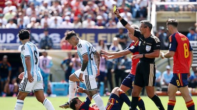 Argentina's Lisandro Martinez is shown a yellow card by referee Slavko Vincic. Reuters