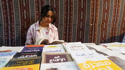 A young bookseller sits at her stall