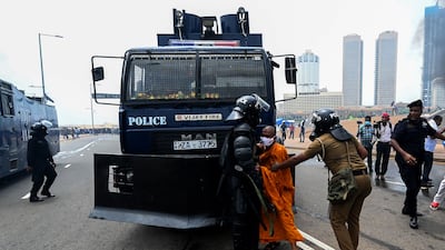 Supporters of the Sri Lankan government attempt to block a police water canon truck. AFP