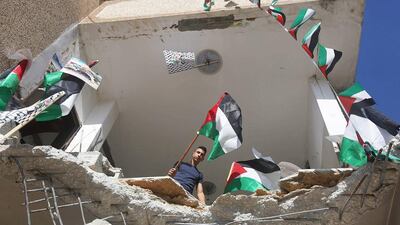 Palestinian flags seen amid the rubble of a house belonging to a Palestinian man who carried out a knife attack in Tel Aviv on March 8 in which an American tourist was killed. The house in the village of Haja, in the Israeli-occupied West Bank, was demolished by Israeli security forces on June 21, 2016. Jaafar Ashtiyeh / AFP