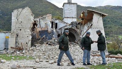 Officers of the state forestry corp national police stand in front of a collapsed church in Campi di Norcia, central Italy. Emiliano Grillotti/Reuters
