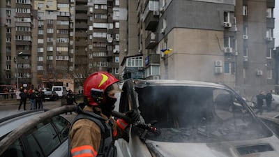 Emergency workers put out fires in Kyiv after a Russian missile strike. Reuters