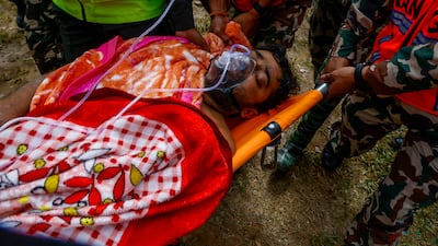 A rescued worker is treated outside a tunnel at the hydropower site in the Rasuwa district, which was devastated by the flood. EPA