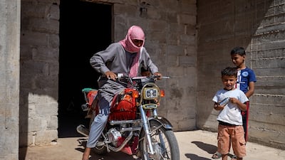 Syrian shepherd Ghiyath Ibn Ja’adan with his children outside their home in Deraa's Dahia neighbourhood. Photo: Ahmad Fallaha / The National