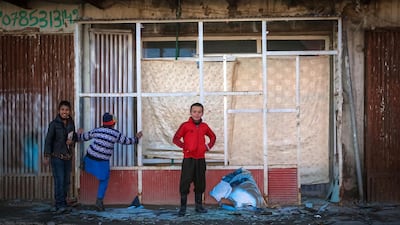 Afghan children look at the broken glass at the site of a rocket attack at a residential house in Kabul, December 12, 2020. EPA