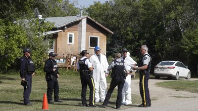 Forensics officials and police officers speak outside the crime scene where stabbing victim Wes Petterson was found, in Weldon, Saskatchewan. AFP