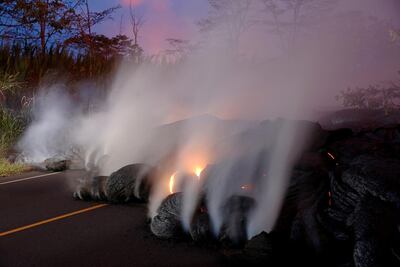 Volcanic gases rise from the Kilauea lava flow that crossed Pohoiki Road near Pahoa. Reuters.