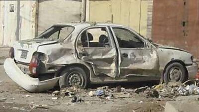 A damaged vehicle lies on a road after a bomb attack in Baghdad.