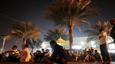 Workers watch a movie on an outdoor projector. Christopher Pike / The National