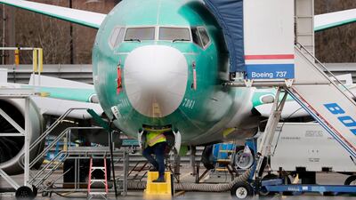 A worker looks up underneath a Boeing 737 Max jet, in Renton, Washington. Boeing has found a new software problem on its grounded 737 Max jetliner. The aircraft maker said it is making the necessary changes and working with the Federal Aviation Administration. AP.