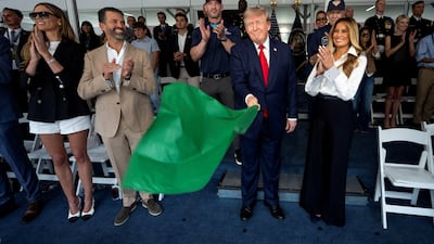 Mr Trump waves the green flag to start the race. Reuters