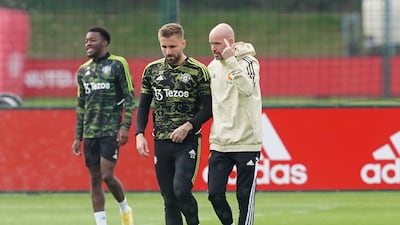 Manchester United's Luke Shaw talks with manager Erik ten Hag during training. PA