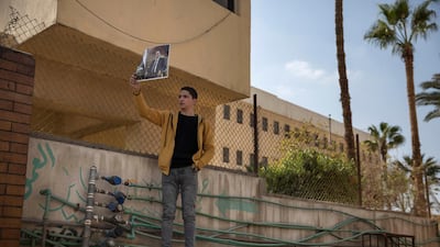 A supporter of former President Hosni Mubarak holds a poster with his photograph near the cemetery where he will be buried. AP Photo