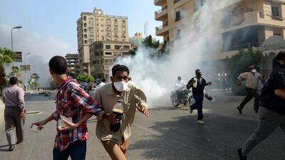 Muslim Brotherhood supporters flee from Egyptian police. Al Jazeera was banned in Egypt for covering Brotherhood protests. Khaled Desouki / AFP