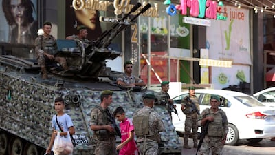 Boys walk past soldiers in Beirut. Six people died during clashes in the Lebanese capital on Thursday. Reuters