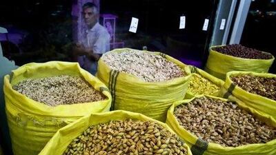 An Iranian man looks at nuts for sale at a nut shop, in western Tehran. Pistachios are Iran's top non-oil export and provide work for hundreds of thousands of people.