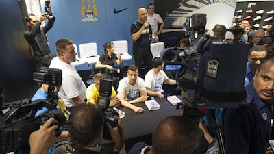 Matija Nastasic (obscured), left, Stevan Jovetic, centre and Samir Nasri, right, during their autograph signing at Marina Mall in Abu Dhabi on Tuesday. Mona Al-Marzooqi / The National / May 13, 2014