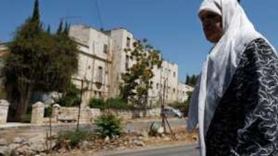 A woman walks in front of the defunct Shepherd Hotel, where a housing project is planned in East Jerusalem.