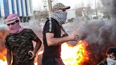 Protesters stand near burning tyres during an anti-government protest demanding free elections and against corruption outside the provincial council building in Basra, Iraq. AP Photo