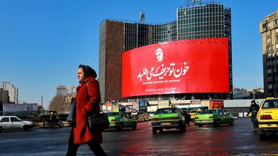 A woman crosses a street in front of a billboard showing a portrait of Qassem Suleimani, who was killed in a US airstrike early on Friday in Iraq, in Tehran, Iran. AP Photo
