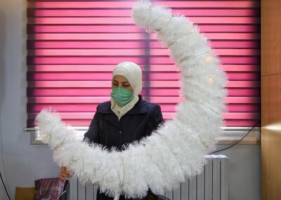 A woman stands near a decorative crescent moon at an orphanage in Damascus. Reuters