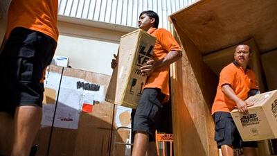Movers load boxes into a truck to be shipped overseas by Allied Pickfords. Some shipping companies are busier than usual due to expatriate families leaving Dubai during the summer months.