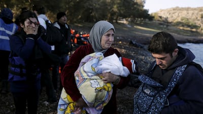 A Syrian refugee woman cries as she holds a baby while refugees and migrants arrive on a boat on the Greek island of Lesbos in 2015. Reuters