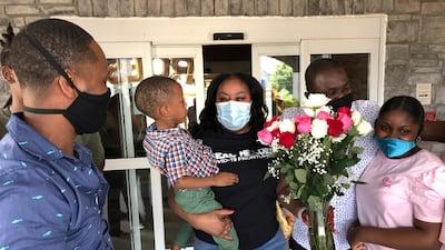 Teisha Roberts, center, a nursing director, is greeted by her family as she prepares to leave Park Springs elder care facility in Stone Mountain, Georgia. Workers who agreed to live at Park Springs to keep its residents safe from the coronavirus are back with their loved ones for the first time in nearly three months. AP Photo