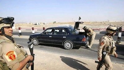 Iraqi security forces search a car at a checkpoint in Basra, southeast of Baghdad, Iraq, on Tuesday.