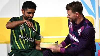 Pakistan captain Babar Azam cuts a birthday cake with Scotland captain Richie Berrington. AFP