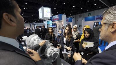 Visitors listen to a briefing from an exhibitor at the POWER-GEN Middle East Conference and Exhibition in Abu Dhabi. Satish Kumar / The National