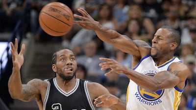 Golden State Warriors forward Andre Iguodala, right, passes around Kawhi Leonard during the first half of an NBA basketball game, Sunday, April 10, 2016, in San Antonio. Golden State won 92-86. (AP Photo/Darren Abate)