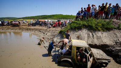 Participants try to free their vehicle from the mire. EPA