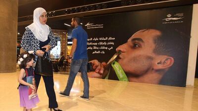 Fans walk past a poster of Ahmed Abughaush. Khalil Mazraawi / AFP