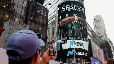 People take photos of a SpaceX advert in New York City. Reuters