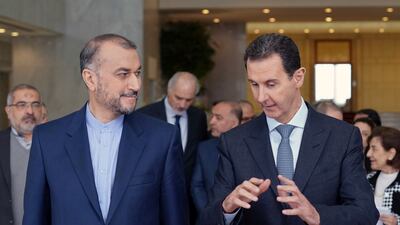Iranian Foreign Minister Hossein Amirabdollahian and Syrian President Bashar Al Assad speak in Damascus on March 23, 2022. Sana via AP