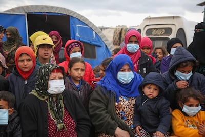 Displaced Syrians, some wearing protective masks, listen as medics explain precautions for dealing with coronavirus in an IDP camp in northwestern Idlib province, on March 18, 2020. AFP