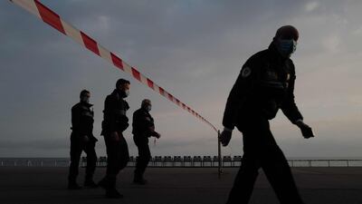 French policemen walk past warning tape on the 'Promenade des Anglais' of the French riviera city of Nice, as the French government announced two weekends of confinement from February 26 in the coastal strip of Alpes-Maritimes to limit the spread of the coronavirus pandemic. AFP