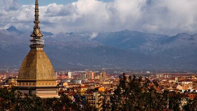 The 167-metre-tall Mole Antonelliana, which is home to the National Museum of Cinema, towers above the rooftops of the Italian city of Turin. The Alps are visible in the background. Getty Images