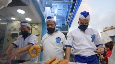 Tunisian cooks prepare a local version of the doughnut, known as Bambalouni, in the village of Sidi Bou Said, northeast of Tunis. AFP